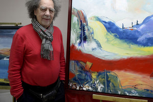 Photo of Rene Gagnon in front of one of his large painting in his studio.